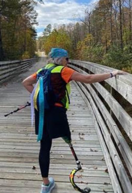 A Team Hawthorne walker crossing a wooden trail bridge