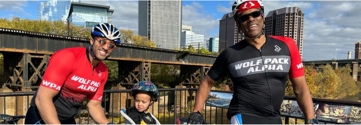Riders from Wolf Pack Alpha with a young rider on a bridge overlooking downtown Richmond
